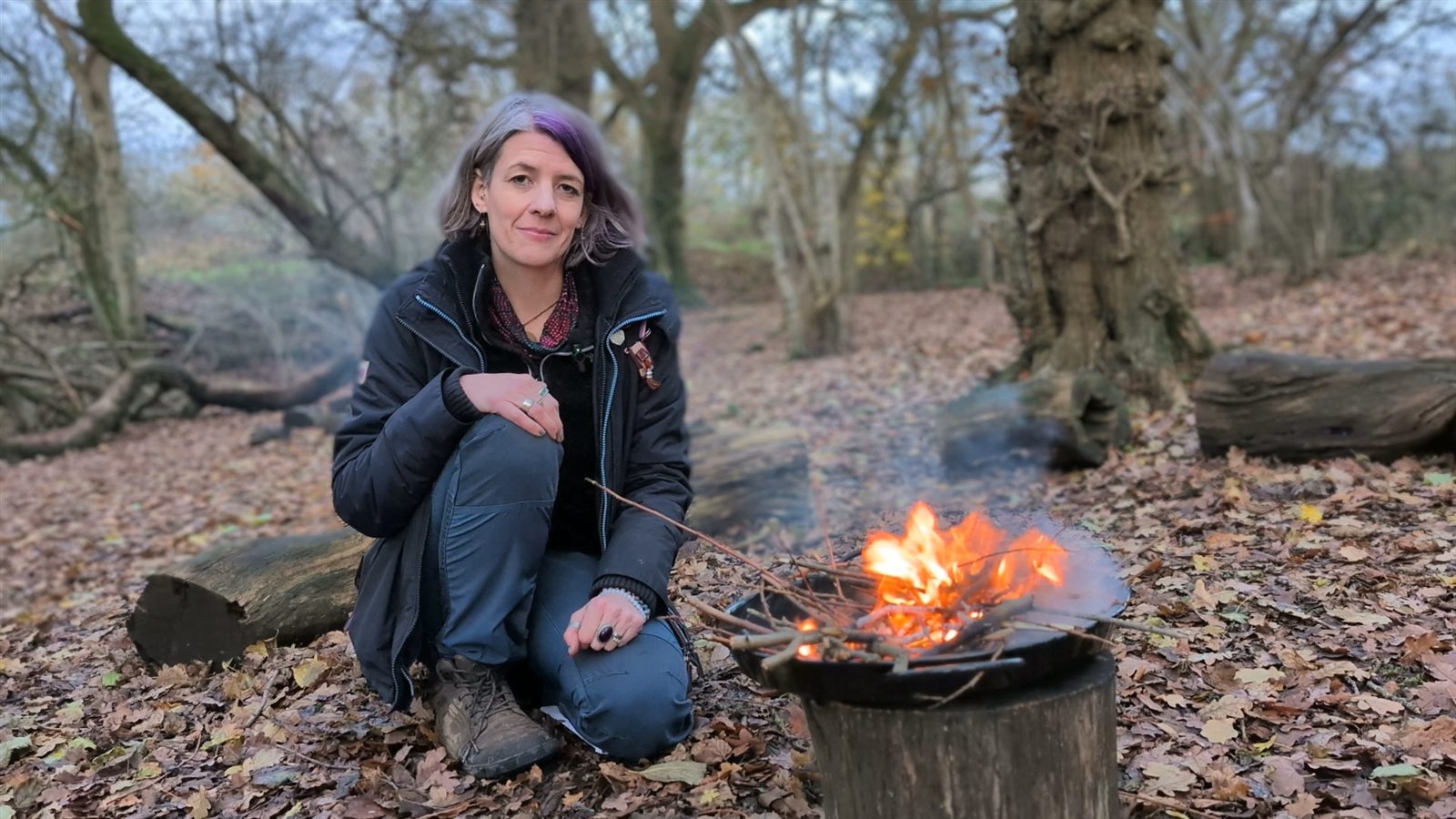 Sarah Allington tending a fire in the woodland Forest School setting