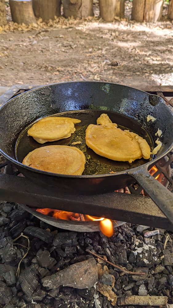 Bannock cooking in a cast iron pan over the fire